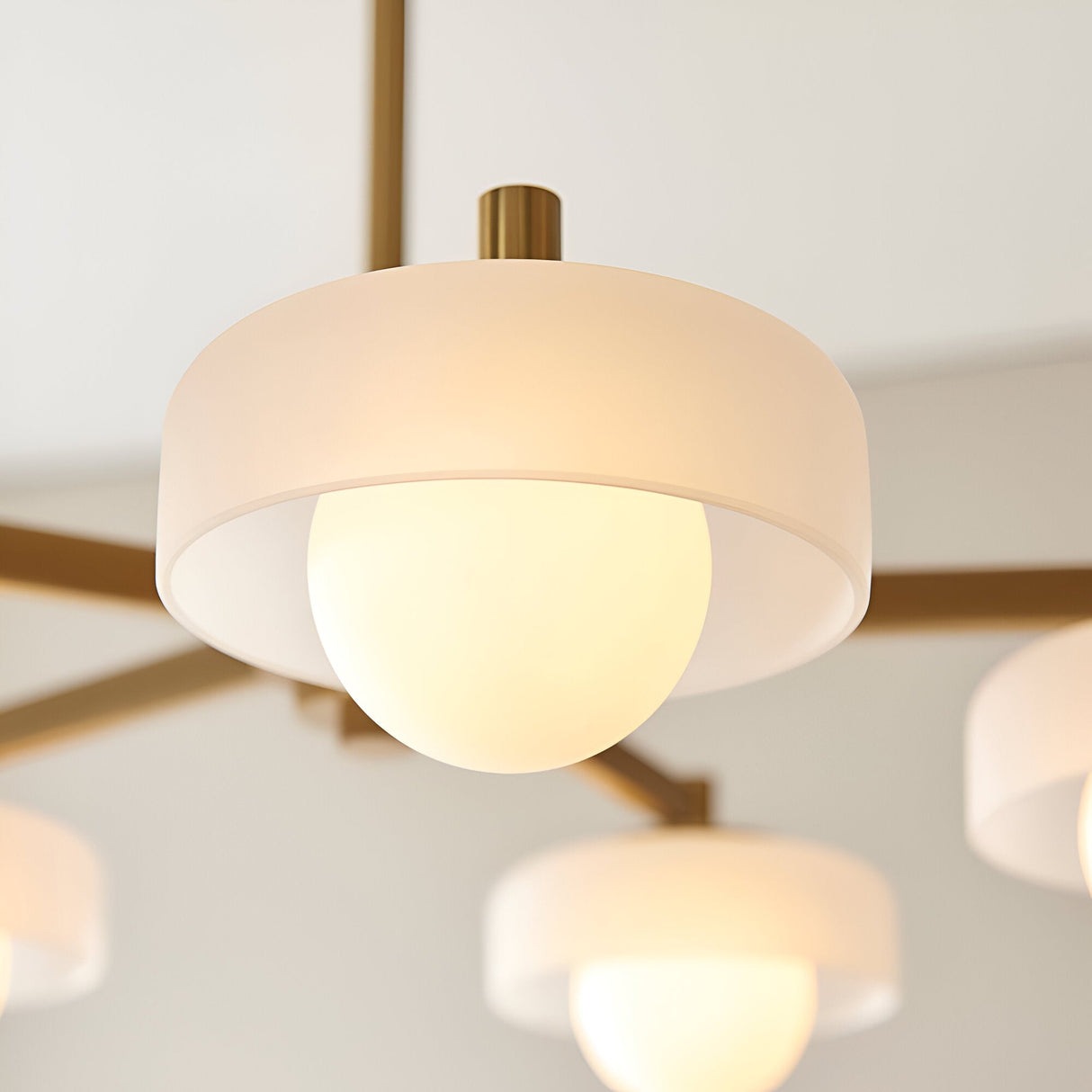 Close-up of Endon Ashby 5 Light Pendant in brushed aged brass, showing a frosted glass drum shade with an opal inner globe.