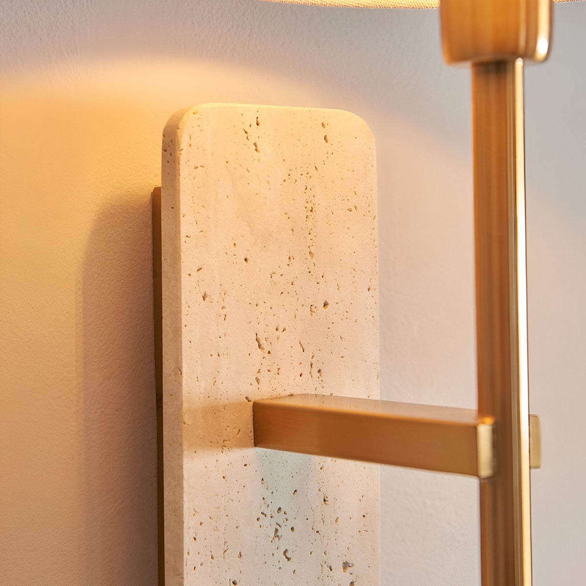Bramble Wall Light in Brass & Natural, close-up of natural stone backplate with veining and slim brass-toned arm against a light wall.