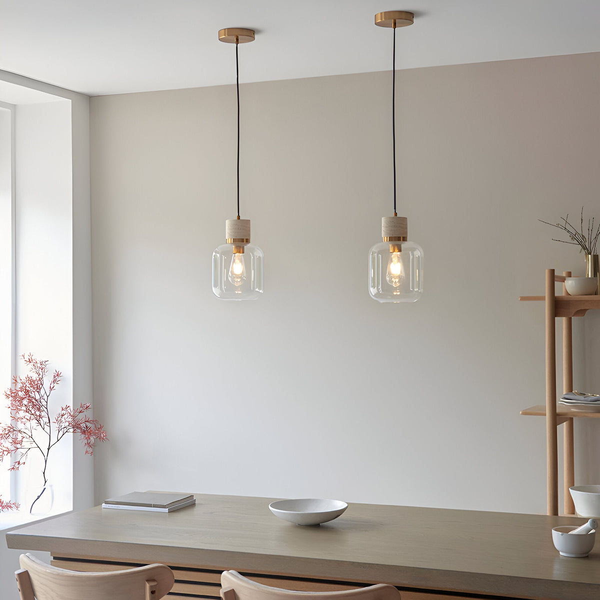 Two Endon Cranstead pendant lights with natural stone tops, brass collars and clear glass shades hanging above a wooden dining table.