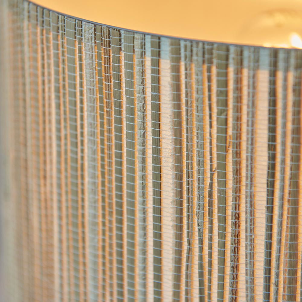 Close-up of the Salcombe Table Lamp's woven seagrass drum shade in natural tones, showing the textured weave and warm glow from within.
