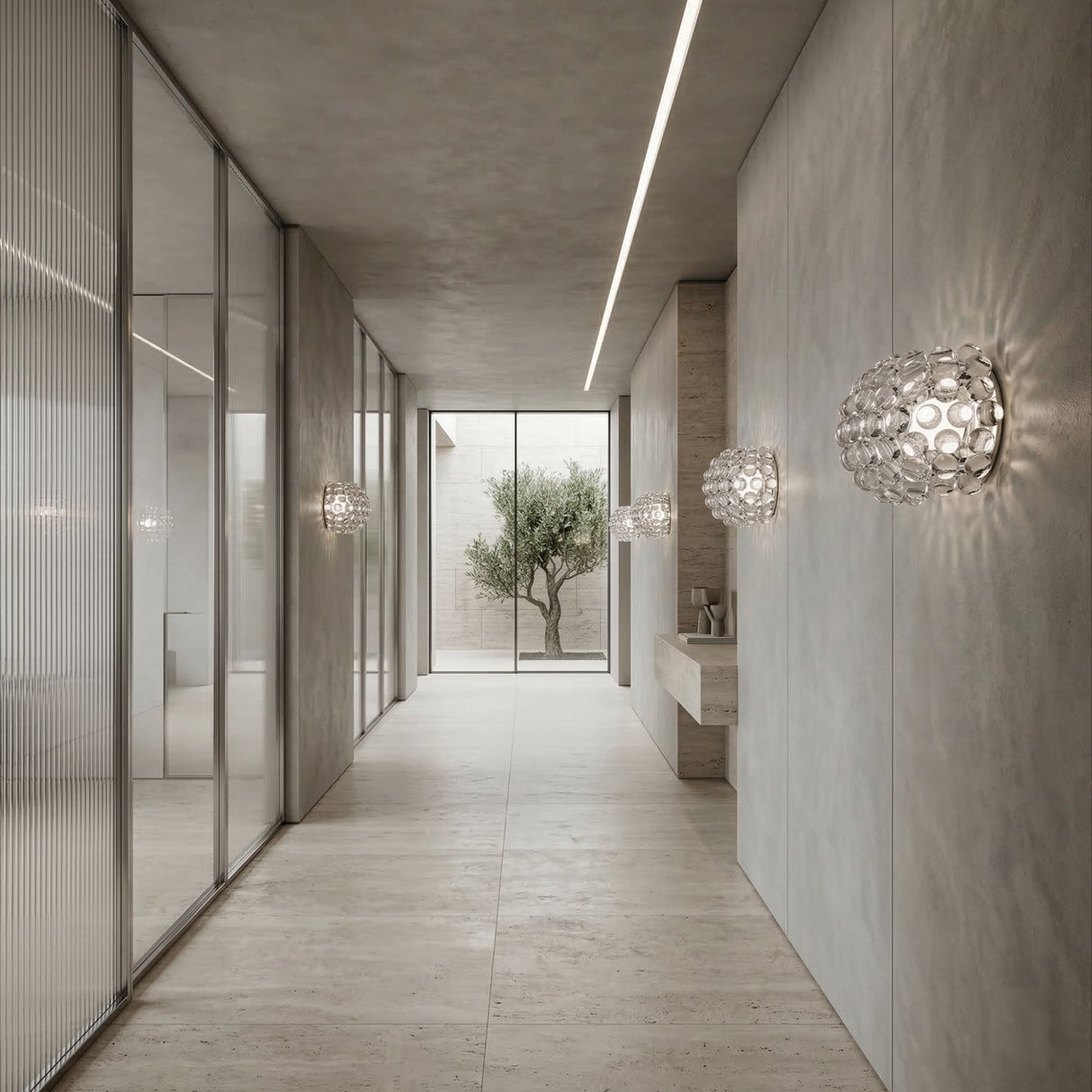 Minimalist hallway with light gray walls and floor, glass partitions on the left, Briller LED Large Wall Light - Transparent installed, a simple sink on the right, and a large window at the end revealing a small tree outside.