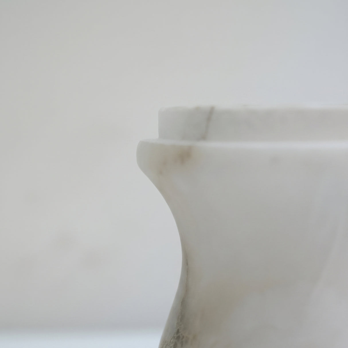 Close-up of the Morfia mushroom table lamp's alabaster dome, showing natural veining and the curved stem detail against a plain light background.