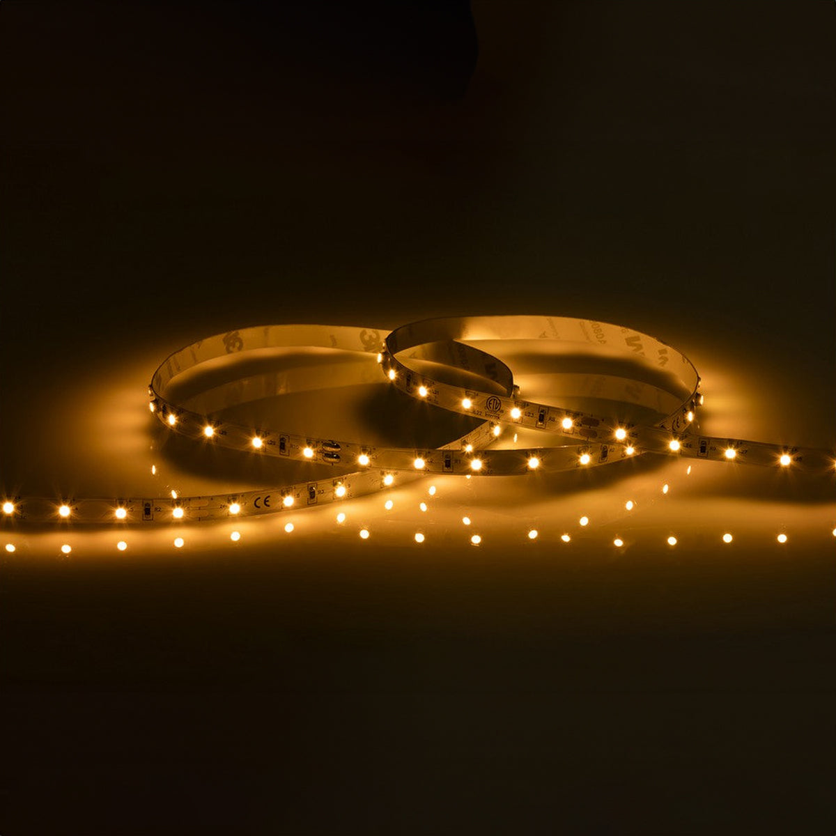 A 1-meter length of the 24V Yellow LED Strip Light emits a soft glow against a dark background.