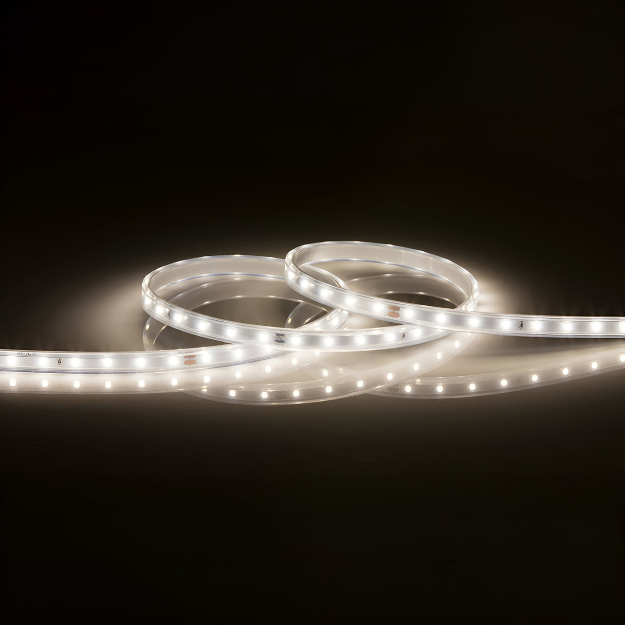 The 24V LED Strip Light IP67 4000K - 3m is elegantly wound in a loop against a dark backdrop, emitting a gentle white glow and featuring color-changing capabilities.