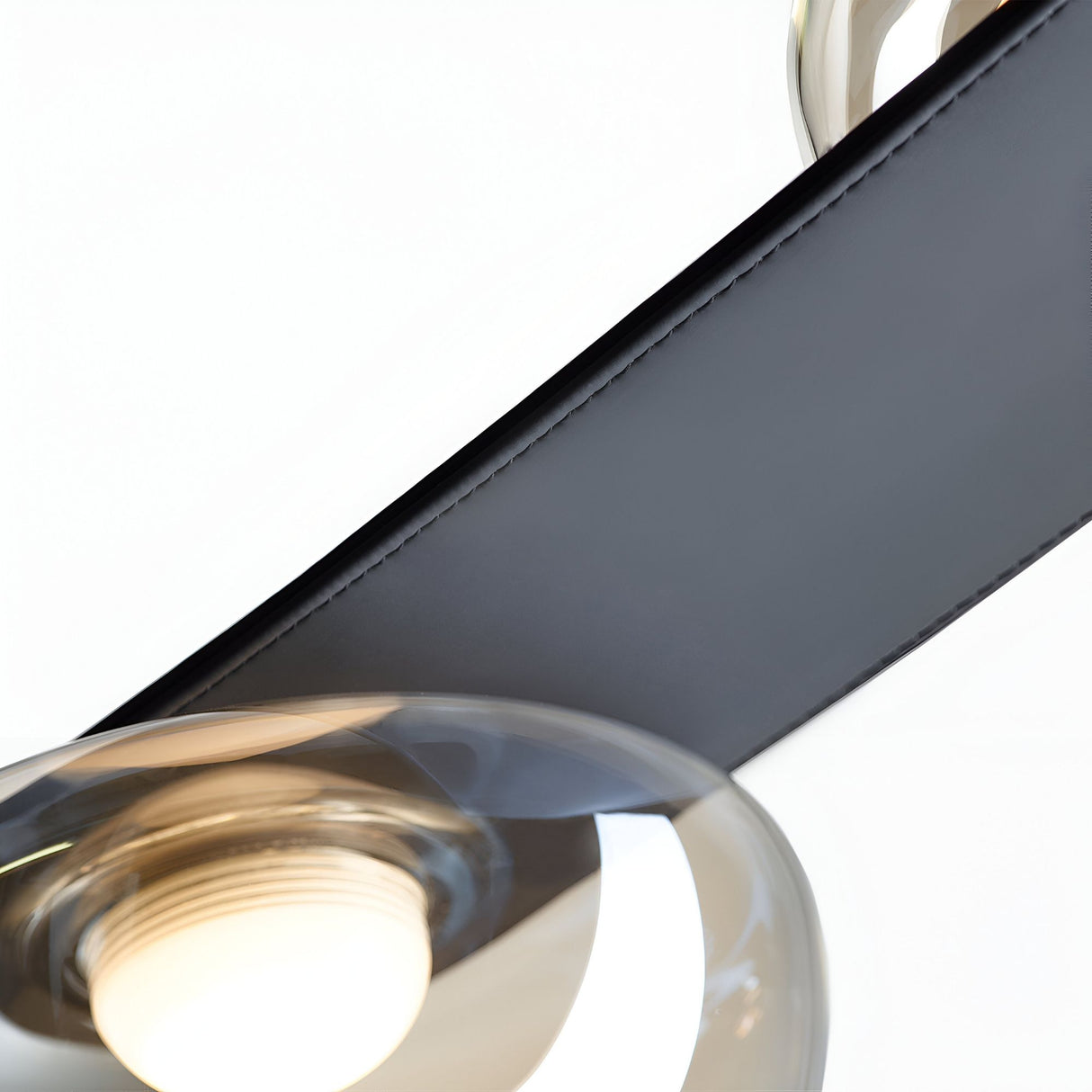 A close-up of the Cordaro 7 Light Leather Suspension in Black, featuring a diagonal metal bar and two circular glass lamp covers, set against a white background.