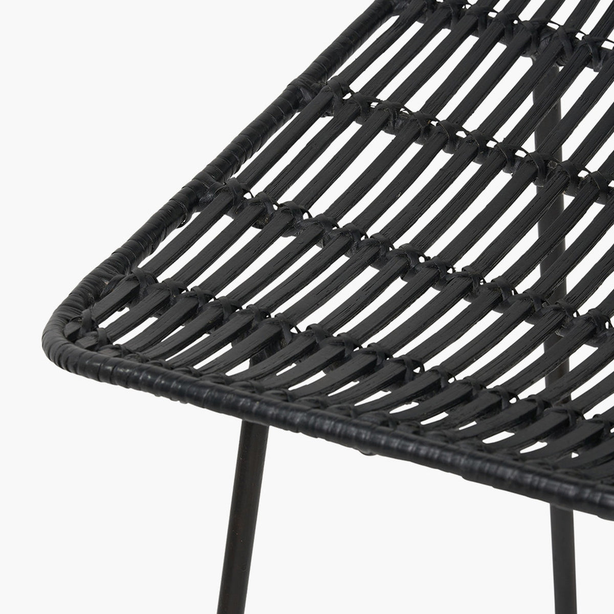 Close-up of the Black Rattan Core & Iron Dining Chair, showing woven black rattan strands over a metal frame with visible leg support, on a plain white background.