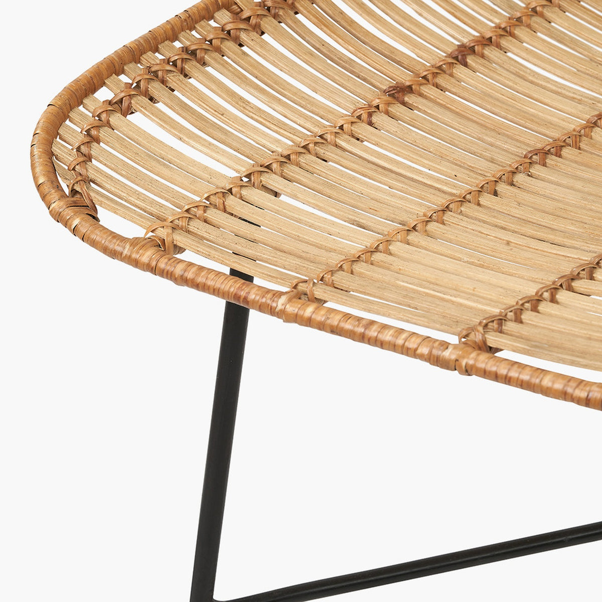 Close-up of a Rattan Core & Black Iron Dining Chair showing the woven natural rattan seat detail and angled black metal legs on a plain white background.
