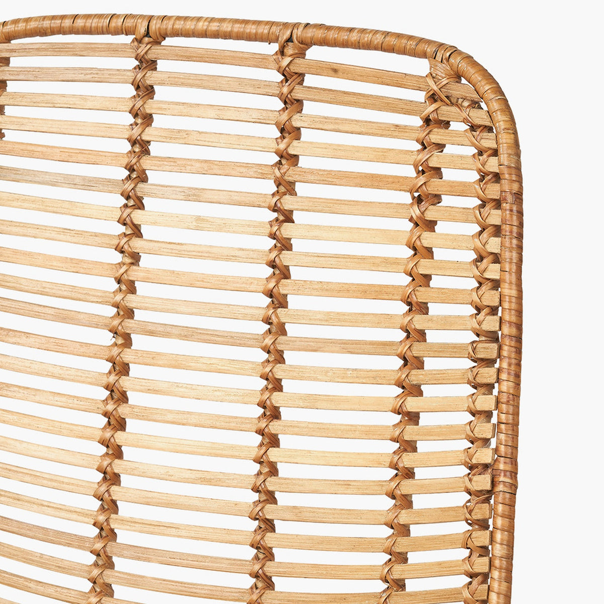 Close-up of the Rattan Core & Black Iron Dining Chair's backrest, showing woven natural rattan strands in a vertical open-slat pattern with a curved frame edge.