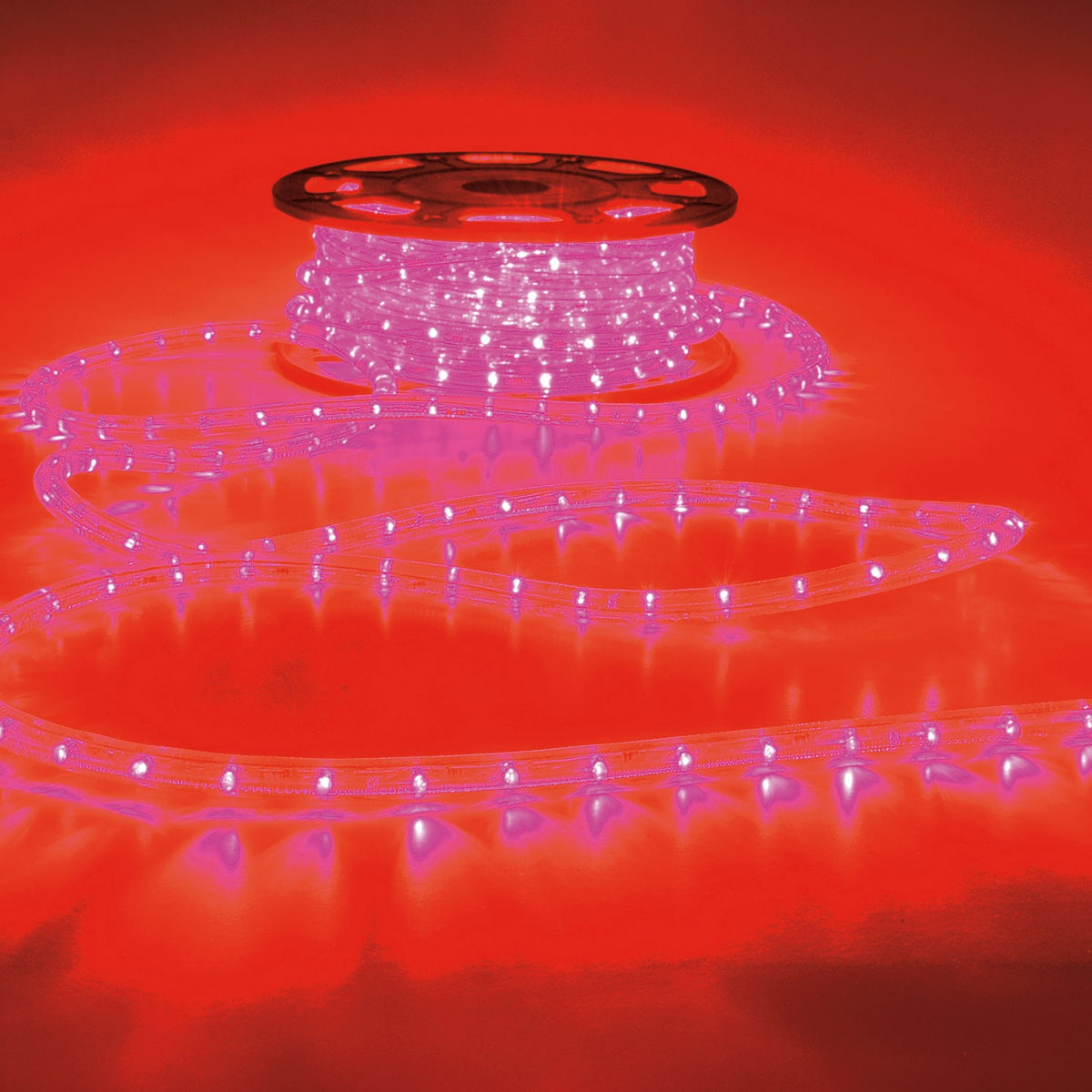 LYYT 230V IP44 50m LED rope light in red, partly unspooled from a reel with illuminated coils trailing across a red-lit surface.
