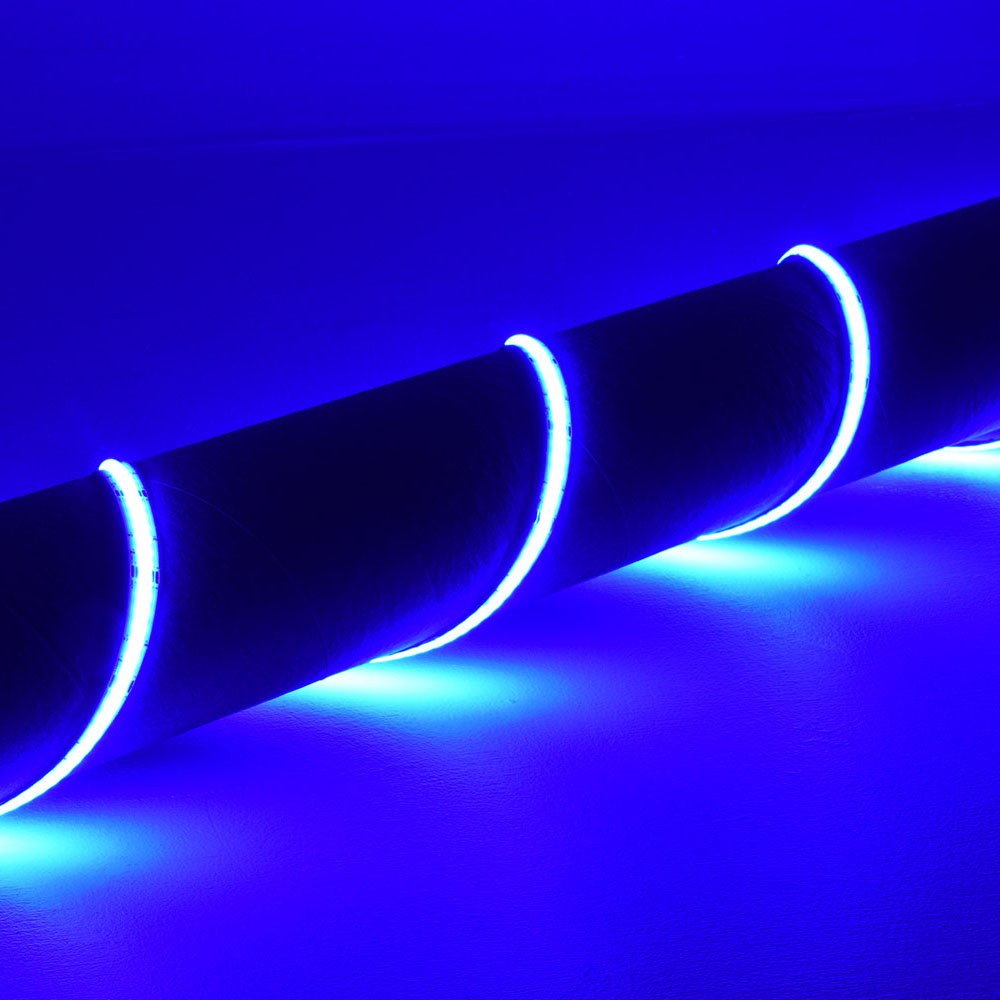 LYYT 24V COB RGB LED strip light by AVSL, coiled around a dark cylindrical form, emitting continuous blue illumination along its 10mm silicone ribbon.