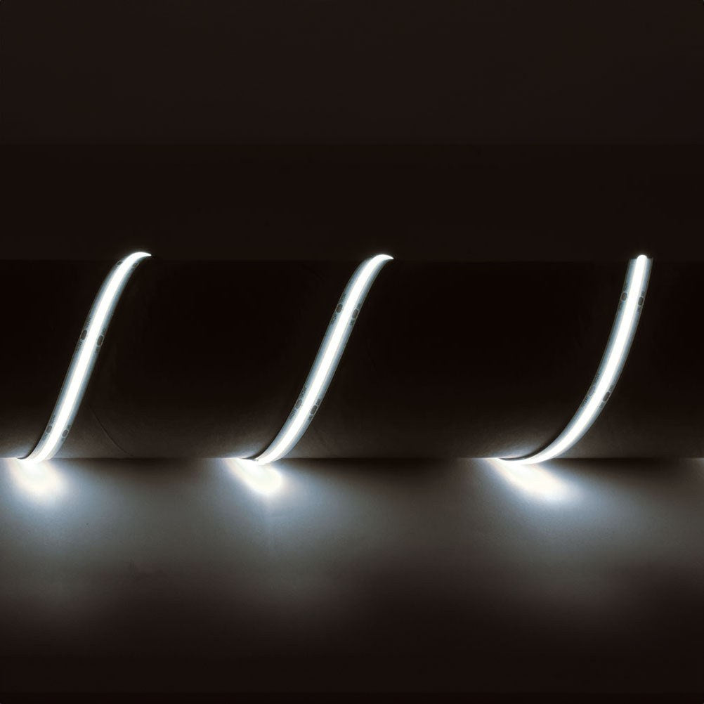 LYYT IP65 24V COB LED strip light illuminated in cool white 6500K, shown in three curved sections emitting bright continuous light against a dark background.