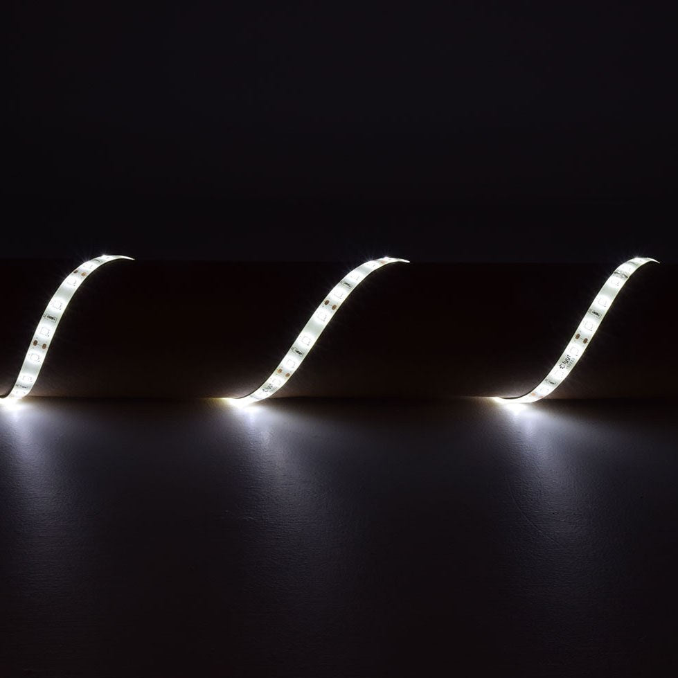 LYYT 12V SMD2835 LED strip light in 6000K cool white, arranged in three flowing curves on a dark surface, showing the flexible IP65 tape lit along its length.