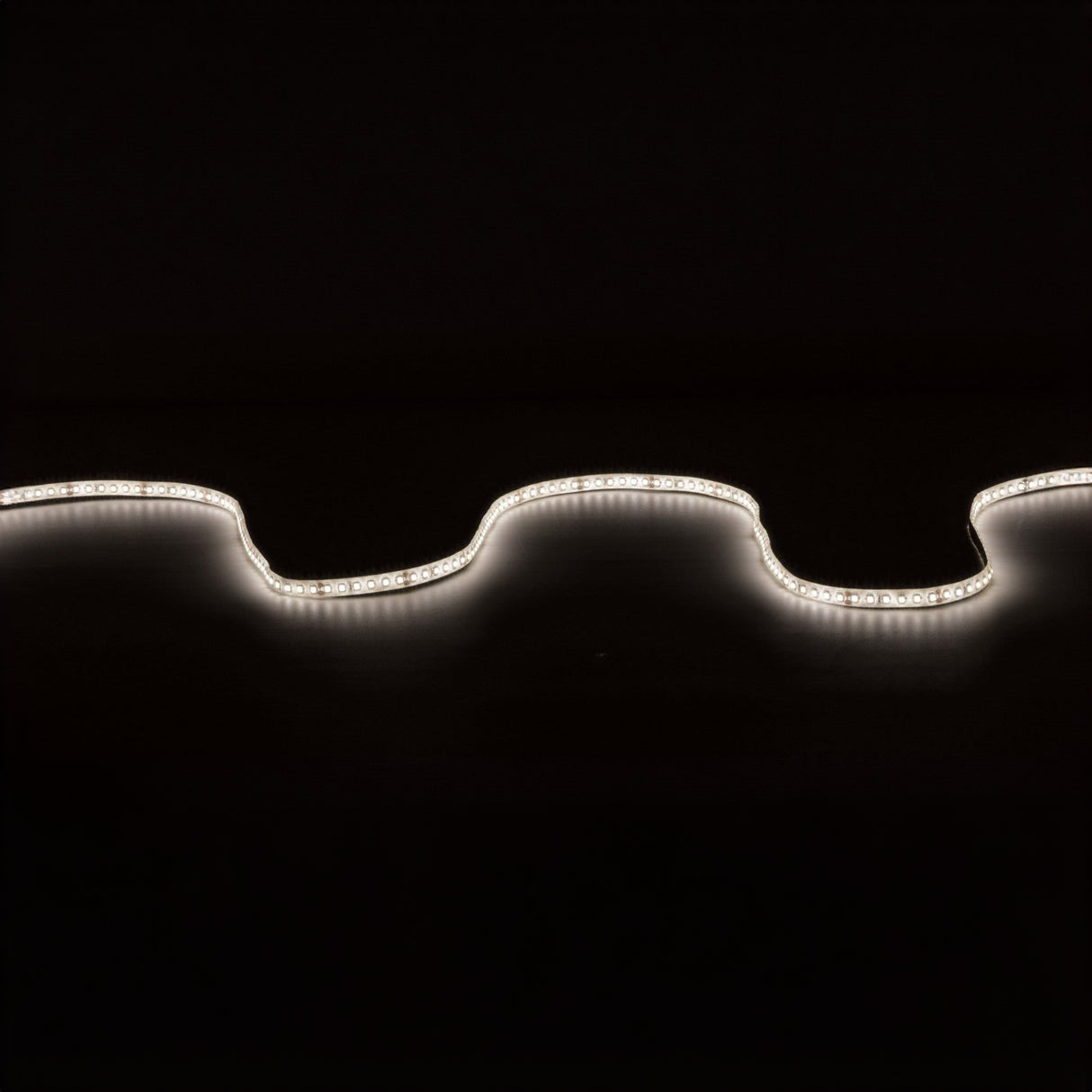 The LYYT 24V High Output LED Strip Light 5m - 4000K softly illuminates against a dark background, forming gentle curves across the image. This water-resistant LED light, with high luminous flux, casts a white glow that contrasts sharply with the black backdrop, showcasing its undulating design and ensuring easy installation anywhere.