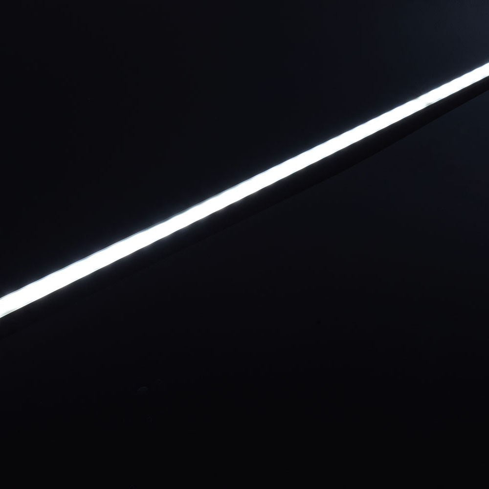 Illuminated LYYT Short Crown 2m surface mount LED profile by AVSL, shown as a bright diagonal line of light against a matte black background.