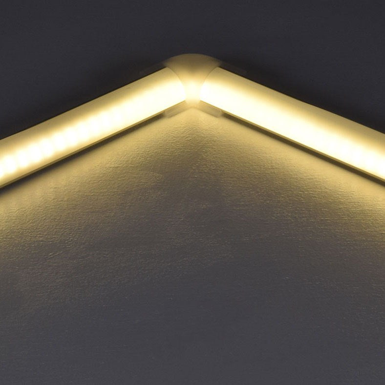 LYYT 90° Arc corner connector by AVSL joining two illuminated LED strip profiles at a right angle, showing the warm diffused light continuing across the bend.