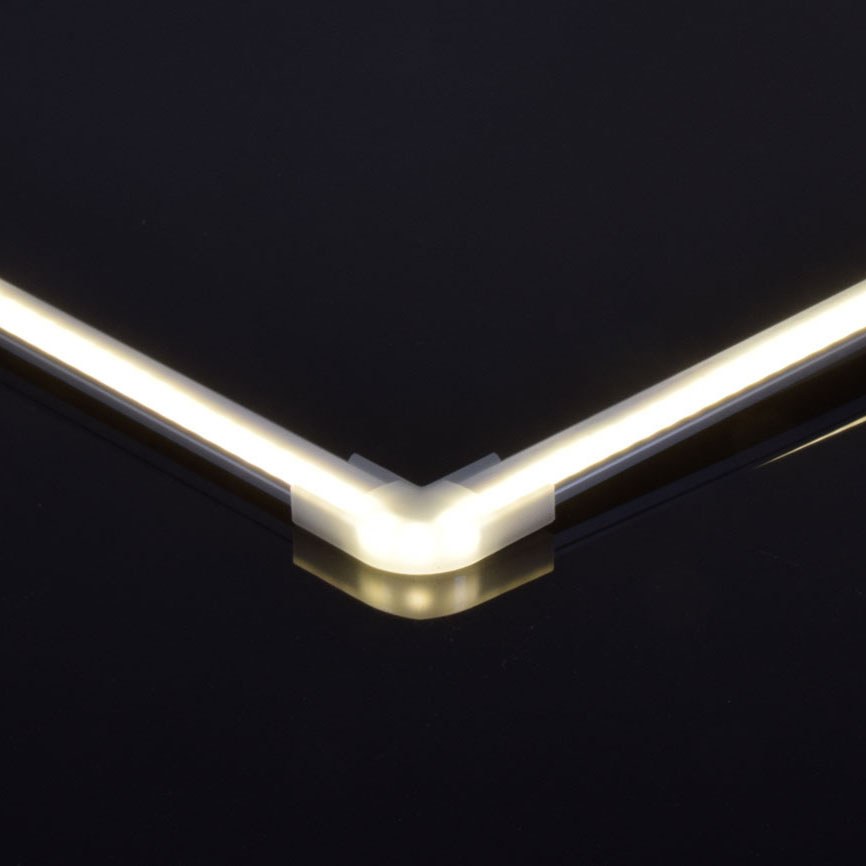 LYYT translucent polycarbonate corner connector by AVSL joining two illuminated LED profile sections at a 90-degree angle against a dark background.