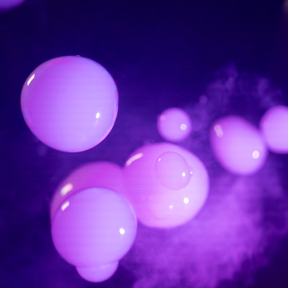 Purple-lit smoke-filled bubbles floating in the air, produced by the QTX FogoSphere 700W compact bubble fog machine from AVSL.