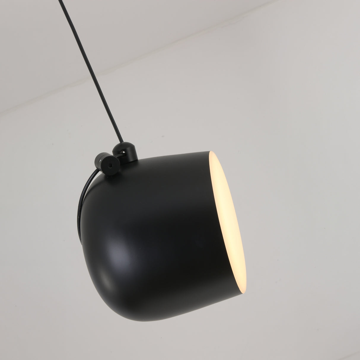 The Mono LED Pendant Light - Black features a modern matte black finish with a glowing white interior, angled downward against a plain white background—perfect for contemporary kitchen lighting.