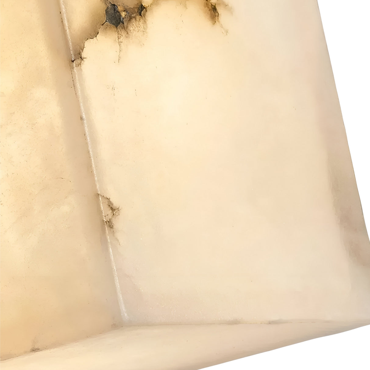 A close-up of the Calmora 1 Light Block Alabaster Wall Light in soft white, showing its light stone texture, dark veins, smooth angular edges, and matte finish—perfect for natural Spanish alabaster accents.