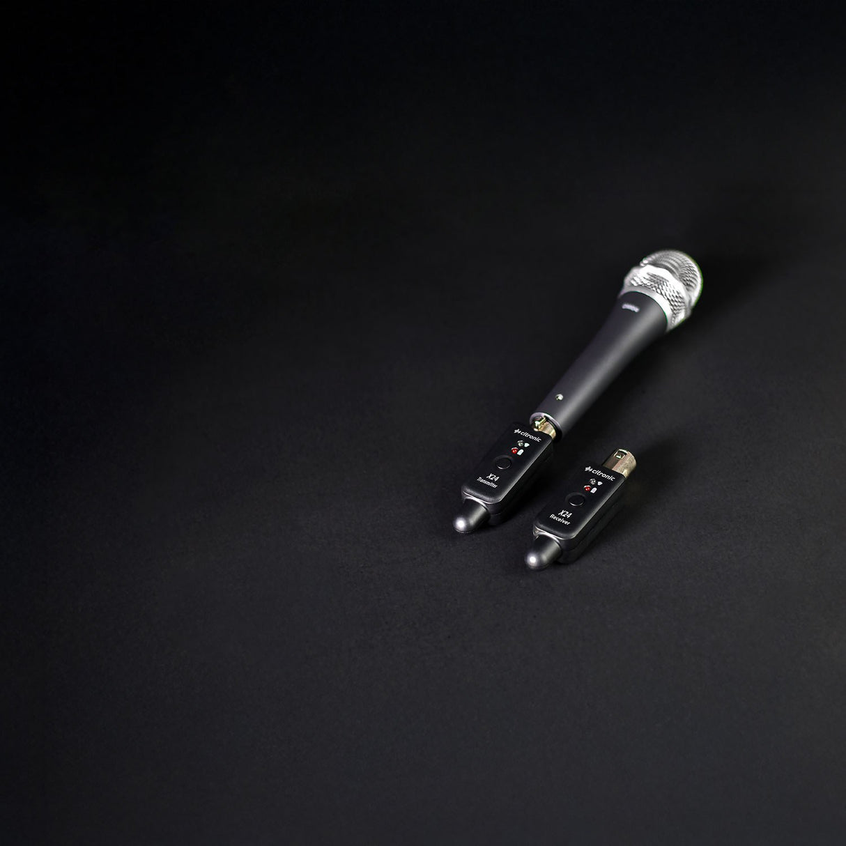 Citronic X24 wireless XLR transmitter and receiver plugged into a handheld dynamic microphone on a black background.
