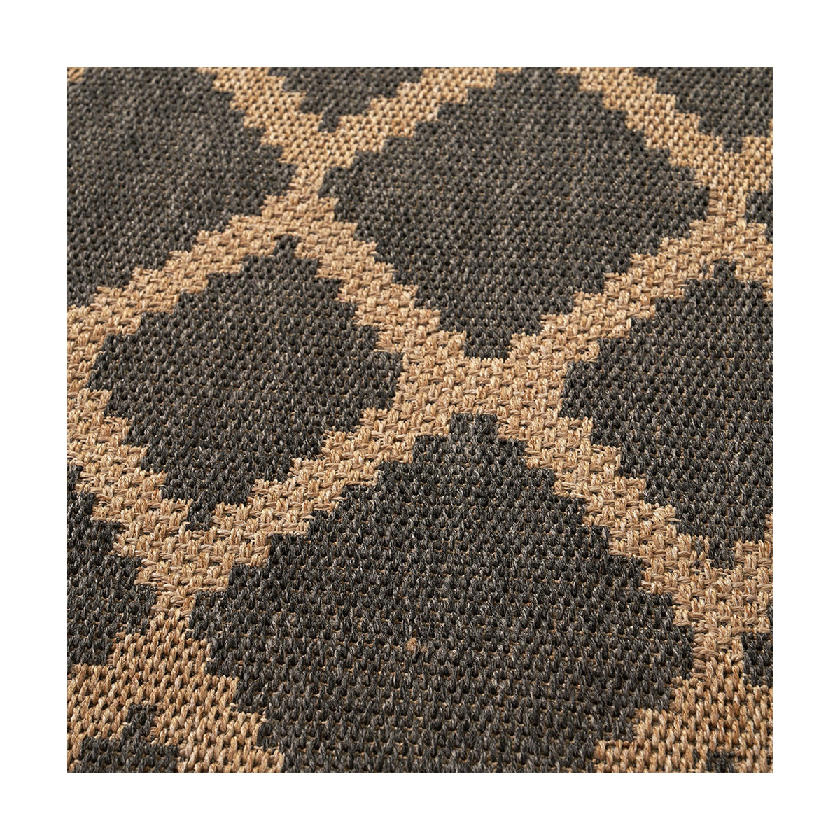 Close-up of an indoor-outdoor rug in slate grey and natural tan, showing a woven diamond trellis pattern in polypropylene fibre.