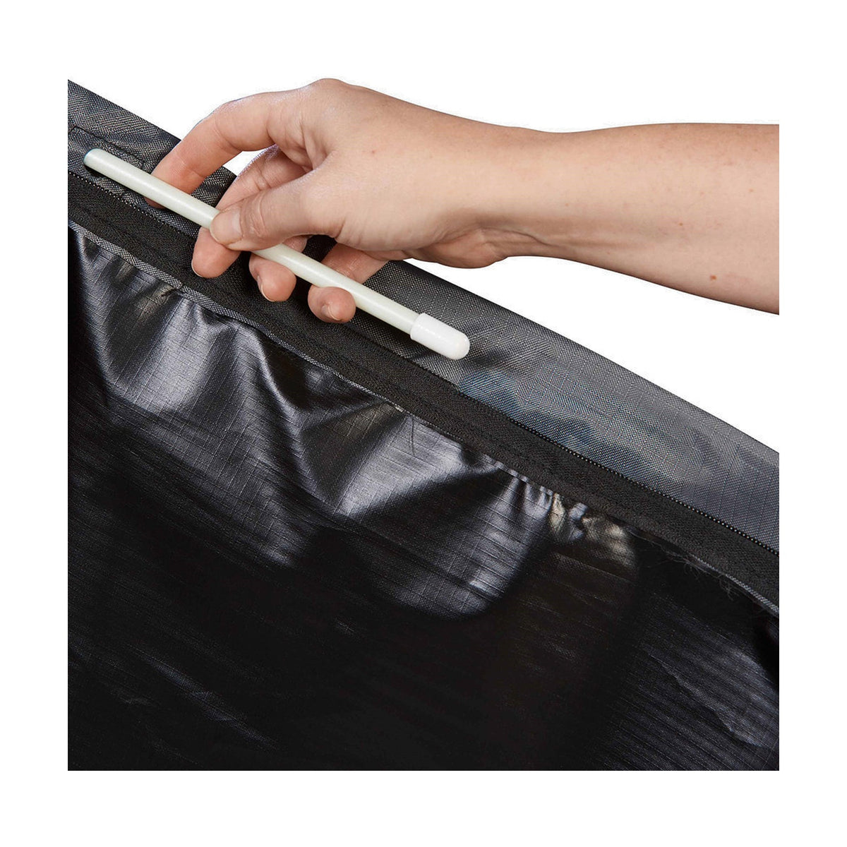 Hand fastening the zip closure on a Cantilever Parasol Aerocover 250, an anthracite fabric outdoor furniture cover, shown in close-up detail.