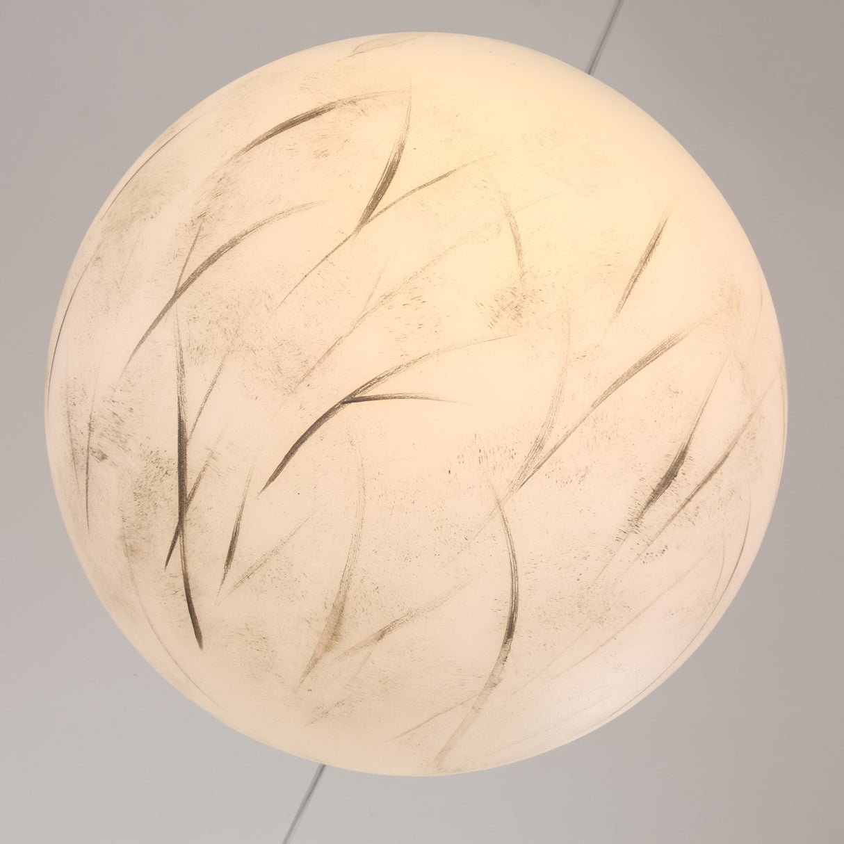 The Lunar Flush Ceiling Light - White features a round frosted glass design with subtle leaf-like patterns, offering hand-painted detail and a soft, warm ambient glow to enhance any space.