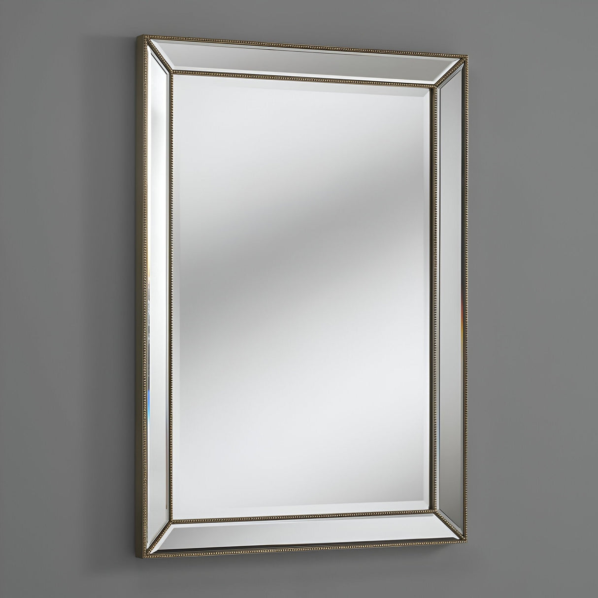 The Celestia Rectangular Wall Mirror in Champagne Gold (91 x 61cm) features a modern geometric design with beveled glass, shown mounted on a plain gray wall and reflecting light without revealing distinct objects.