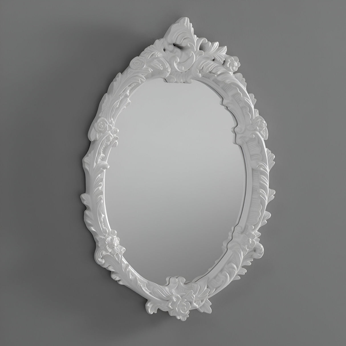 The Mirage Oval Wall Mirror White (64x46cm), featuring a decorative floral and leaf pattern on its white frame, adds vintage style to any plain gray wall.