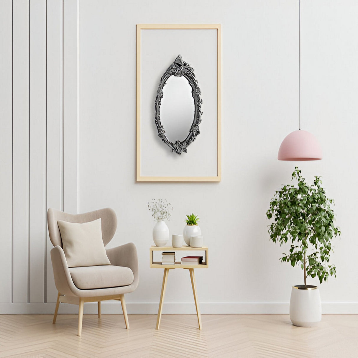 A modern, minimal living room with a beige armchair, small side table with plants, a Mirage Oval Wall Mirror Silver (64x46cm), pink hanging lamp, potted plant, and wooden floor.