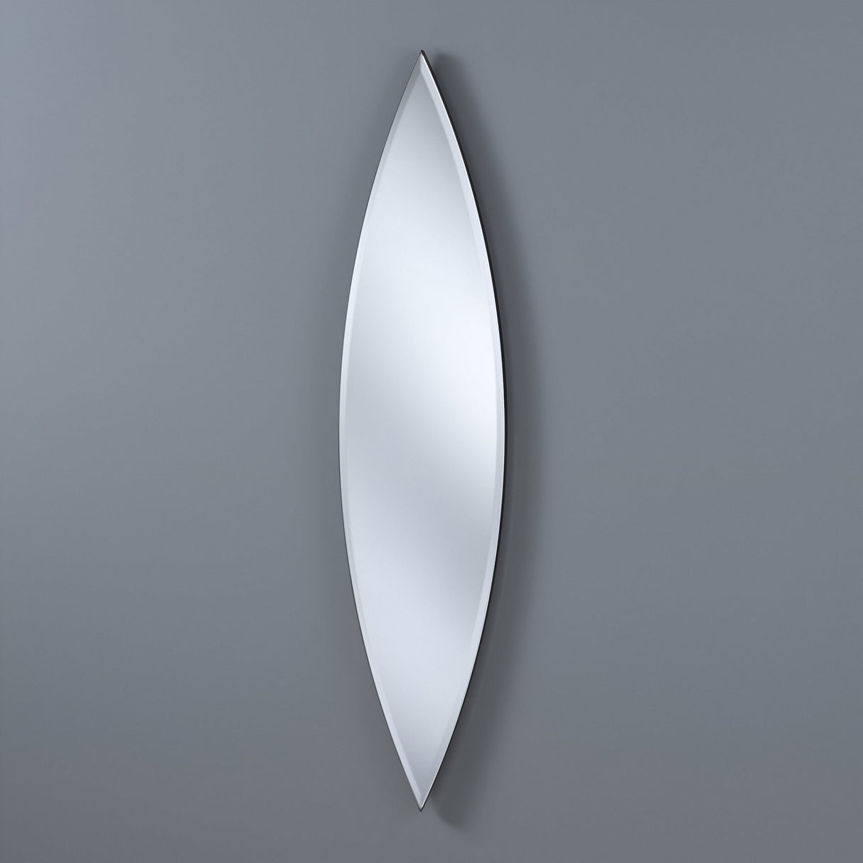 The Aurora Oval Wall Mirror in Bronze & Silver (130x30cm) features a sleek, elongated leaf-like shape with pointed ends and an elegant ellipse design, mounted vertically for a smooth, modern look on any gray wall.