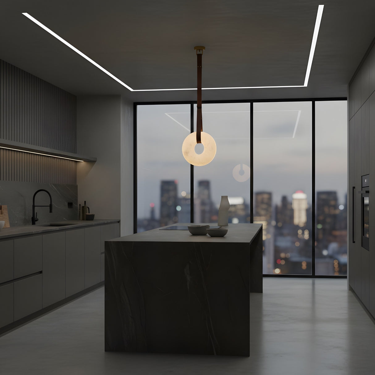 A modern kitchen with dark cabinets, a marble island, minimalist decor, and the Cintura LED Large Alabaster Single Pendant Light (Soft White & Brown). Large windows showcase a city skyline at dusk with glowing buildings beyond.