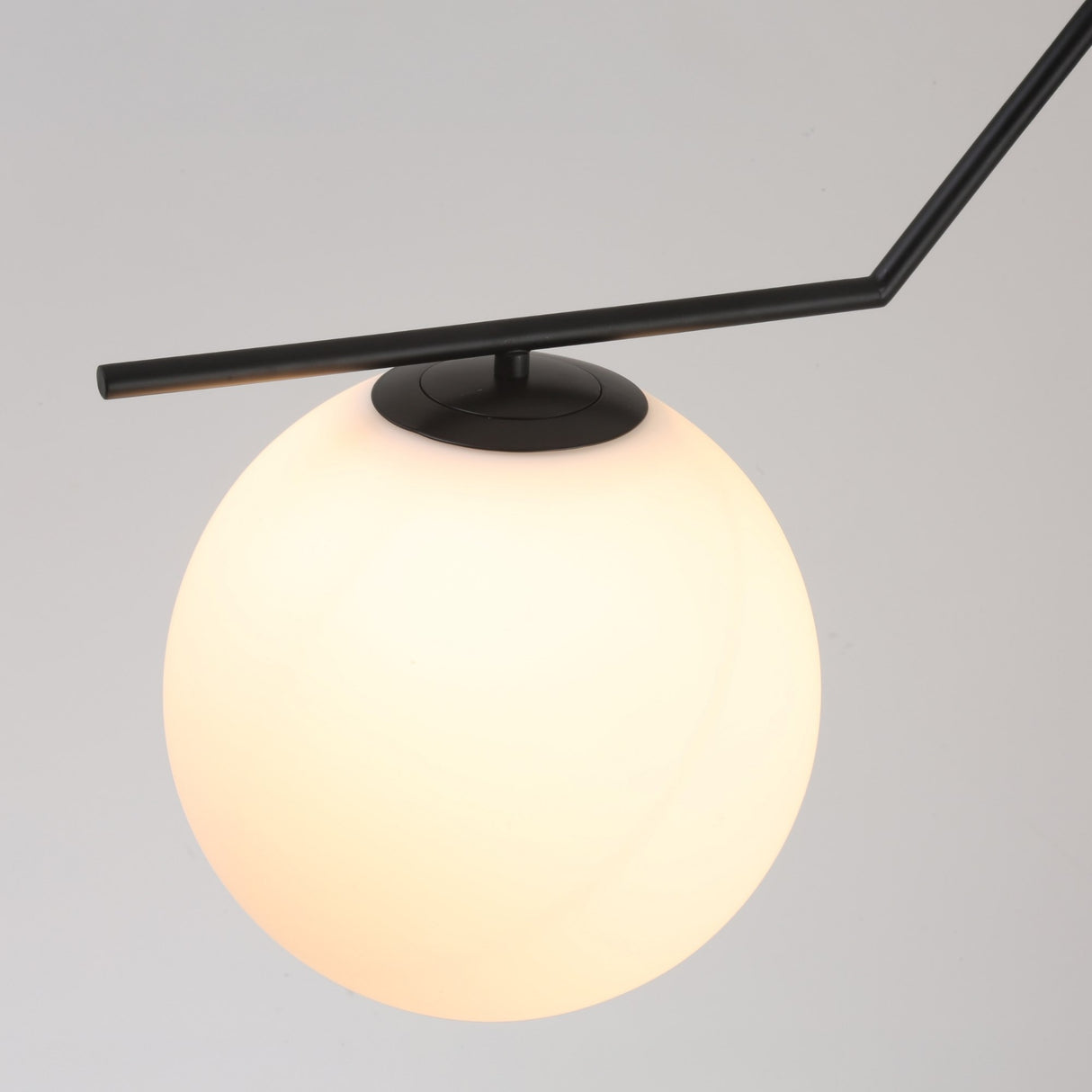 The Vetra Opal Glass Large Pendant Light - Black features a frosted white globe shade on a slim, angled rod—an ideal modern fixture to brighten and elevate any room with contemporary style.