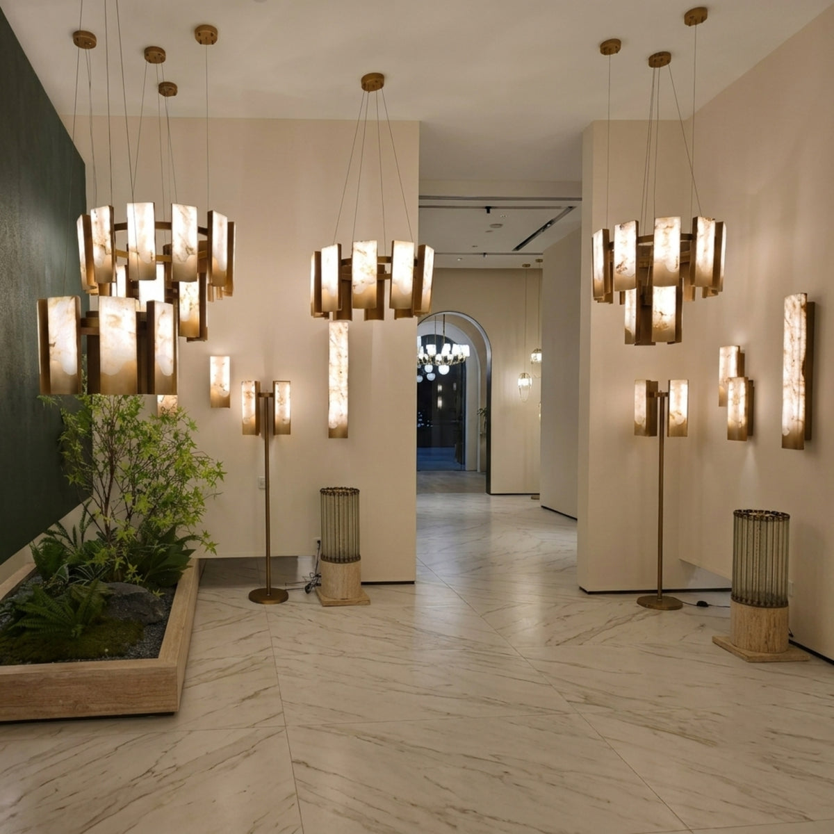 Caelith 10 Light Large Panel Alabaster Chandelier in brushed brass, shown among matching chandeliers and wall lights in a hallway with marble flooring.