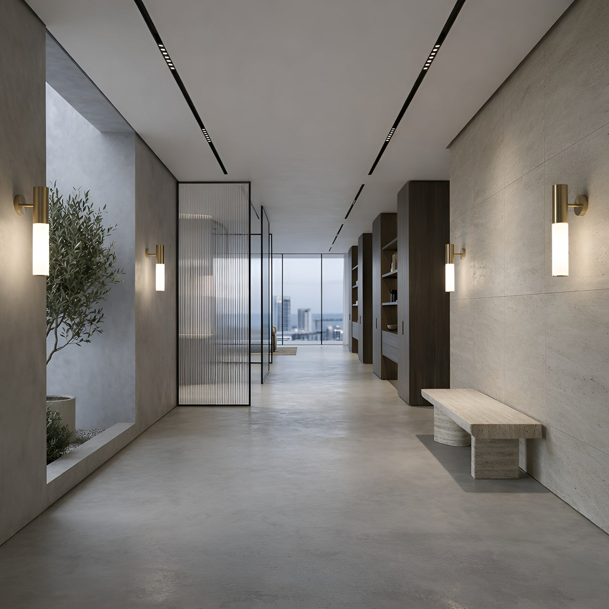 A modern, minimalist hallway with concrete floors, a Magari Wall Light - Gold, a stone bench, built-in shelves, and large windows at the end revealing a city view. An indoor tree stands to the left.