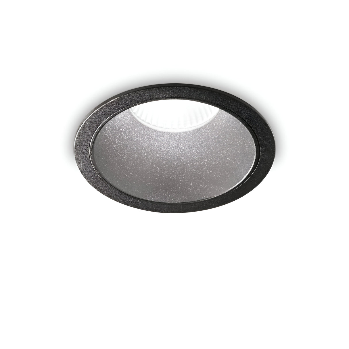 The Sally LED Round Recessed Trim Downlight - 20W, 3000K in black trim and metallic interior casts a gentle glow on a plain white ceiling.
