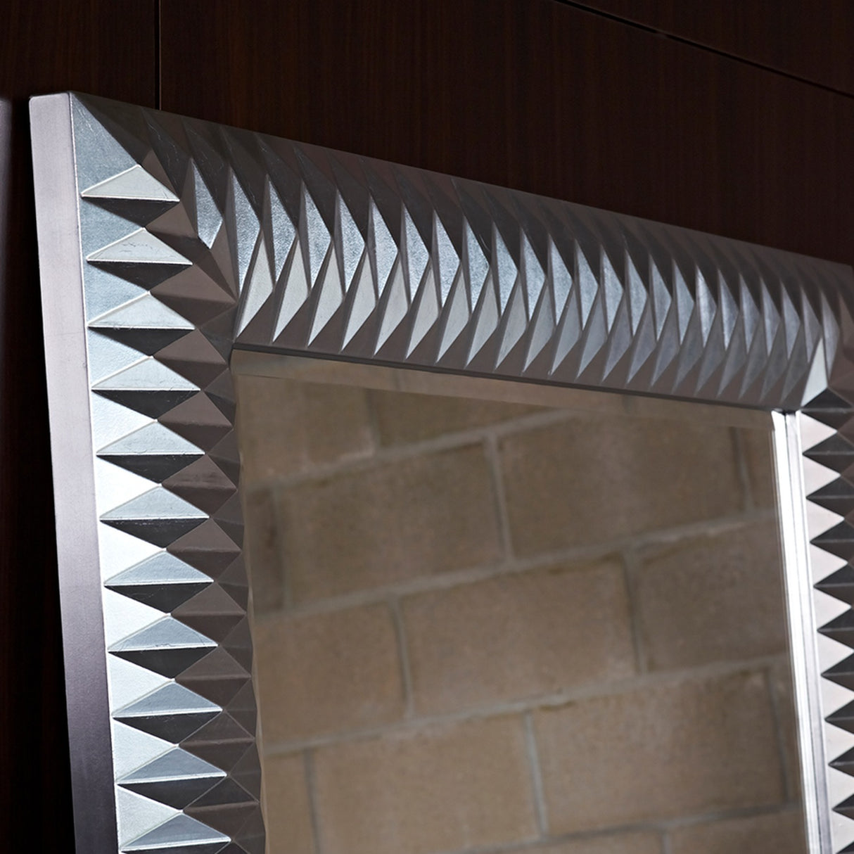 Nick Silver Leaf Full Length Mirror 189cm, close-up of the faceted pyramid-textured frame in silver leaf finish, mounted on a dark wood panelled wall.