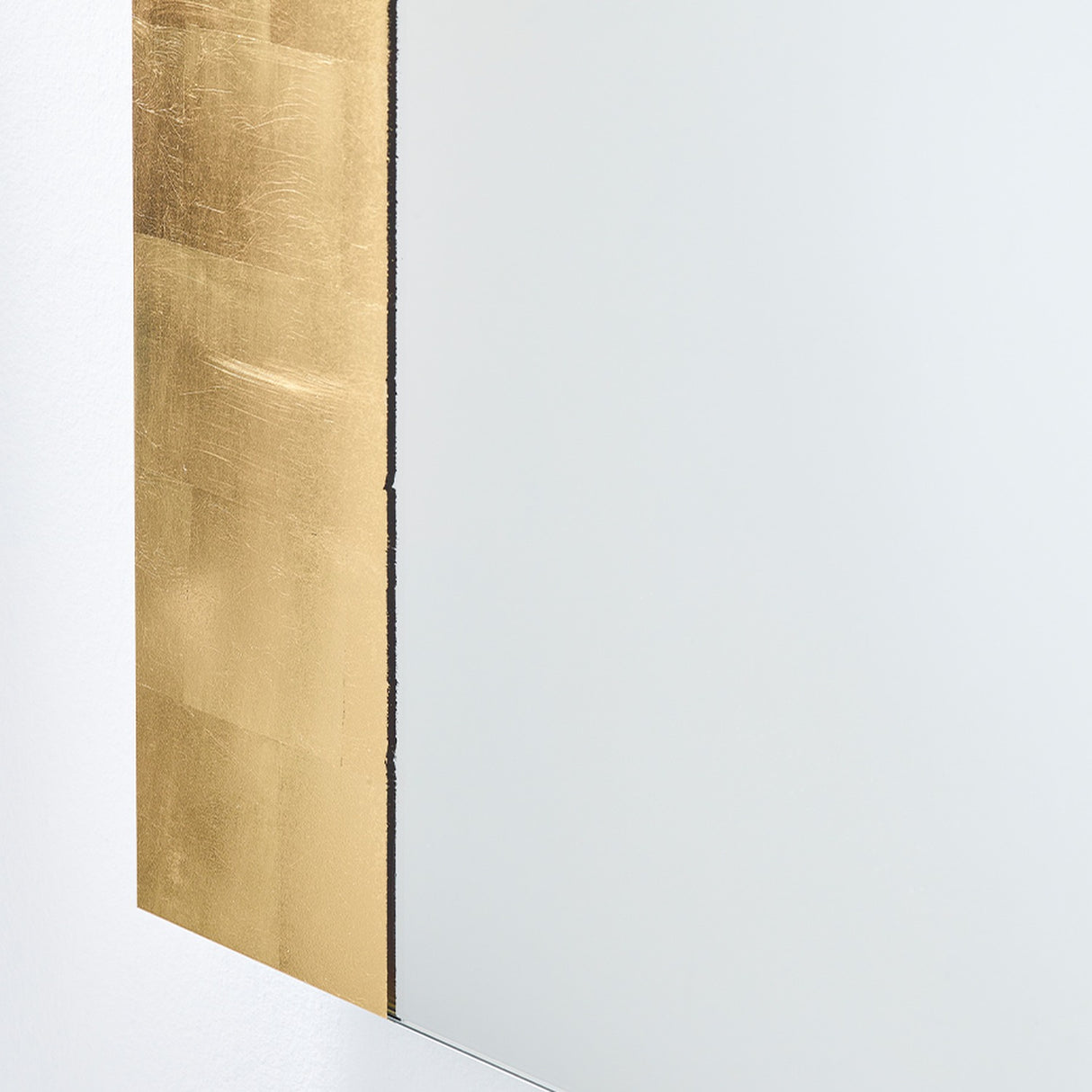 Close-up of the Gallery Gold Leaf Arch Top Wall Mirror 170cm, showing the frameless mirror edge with hand-applied gold leaf in overlapping squares and a torn inner edge.