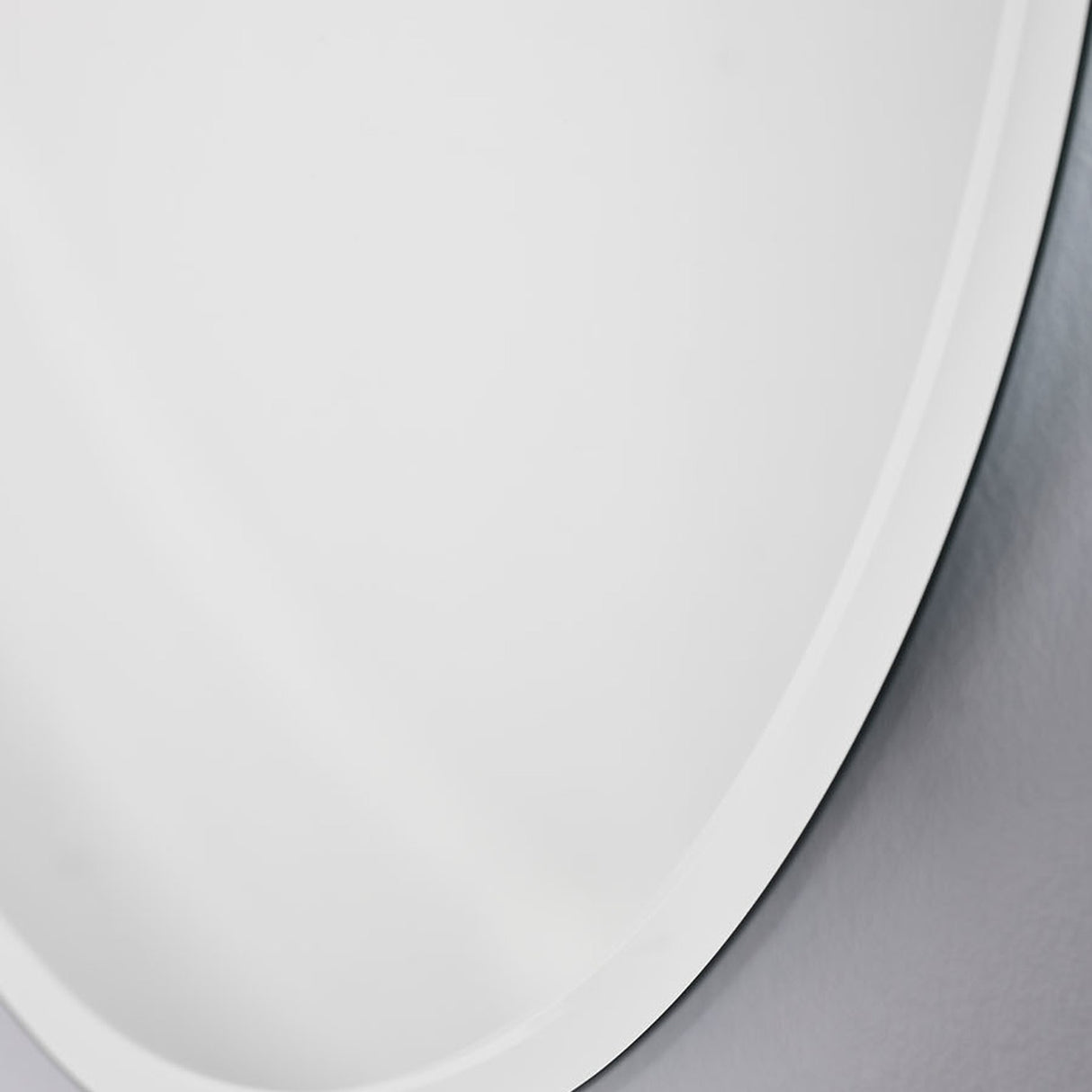 Close-up of the bevelled edge where it curves, the ground band reading brighter than the flat face.