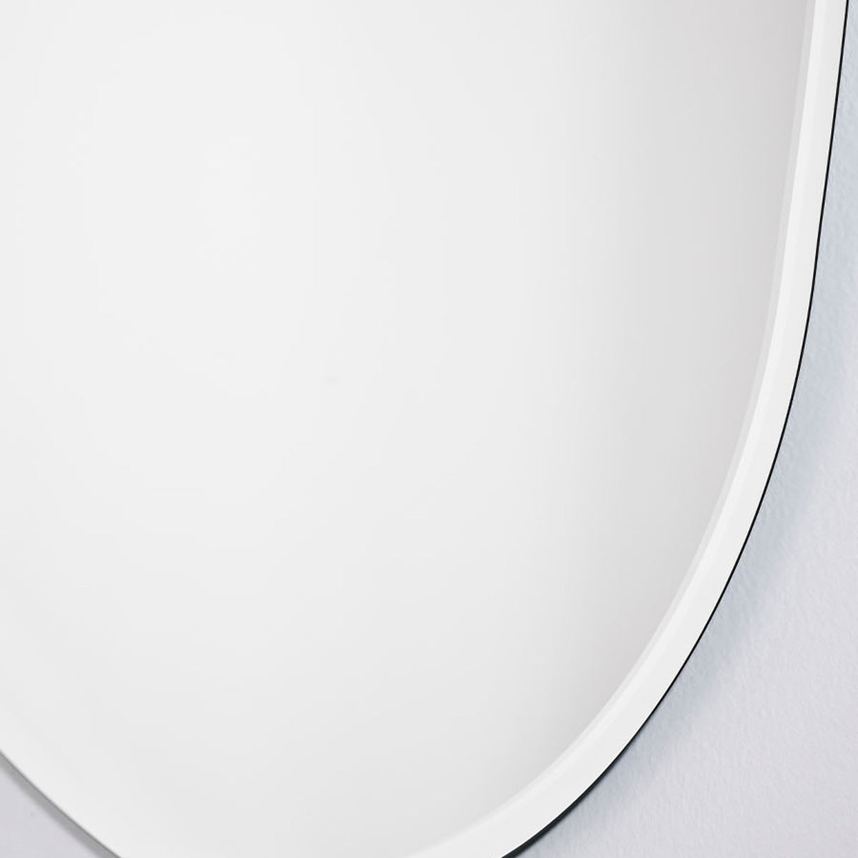 Close-up of the bevel meeting the wall, showing how little the frameless glass stands off the surface.