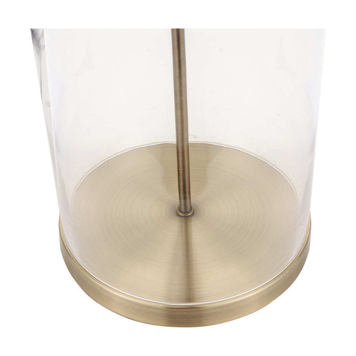 Close-up of the Cloche table lamp's cylindrical clear glass base with antique brass disc foot and central rod, set against a plain white background.