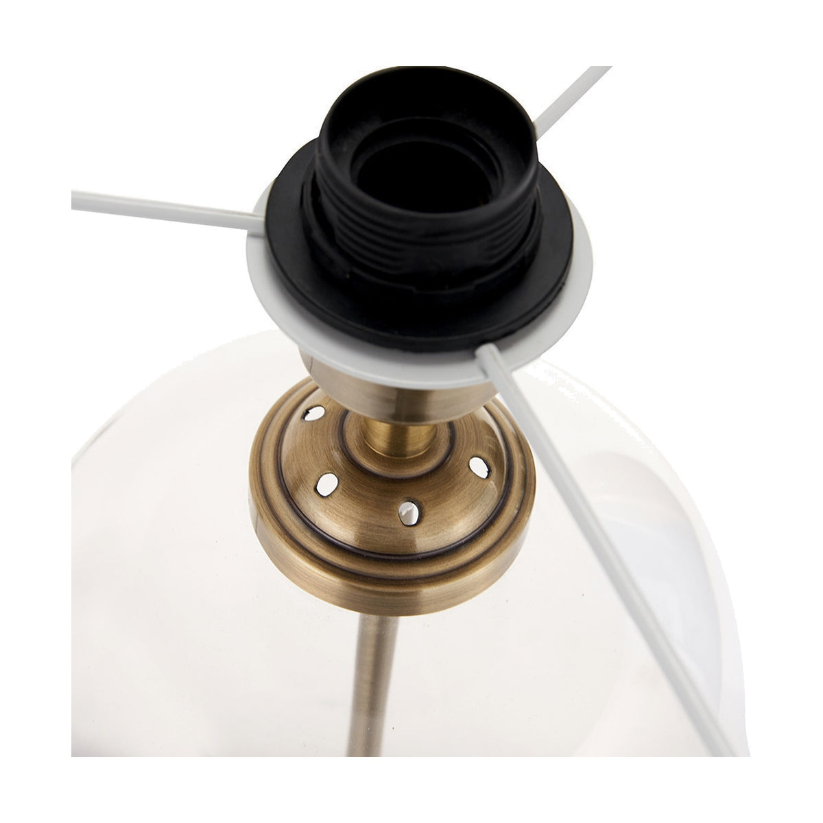 Close-up of the Cloche table lamp's antique brass gallery and black bulb holder, with white metal frame arms and clear glass shade visible against a white background.