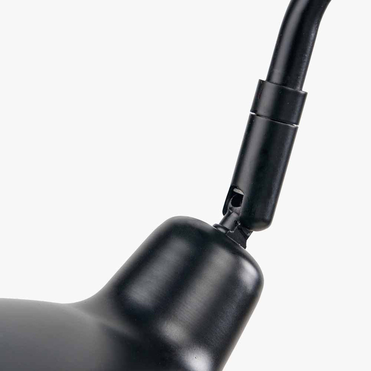 Close-up of the Toulon Black Iron Task Table Lamp showing the matte black metal joint where the flexible arm connects to the rounded base, on a plain white background.