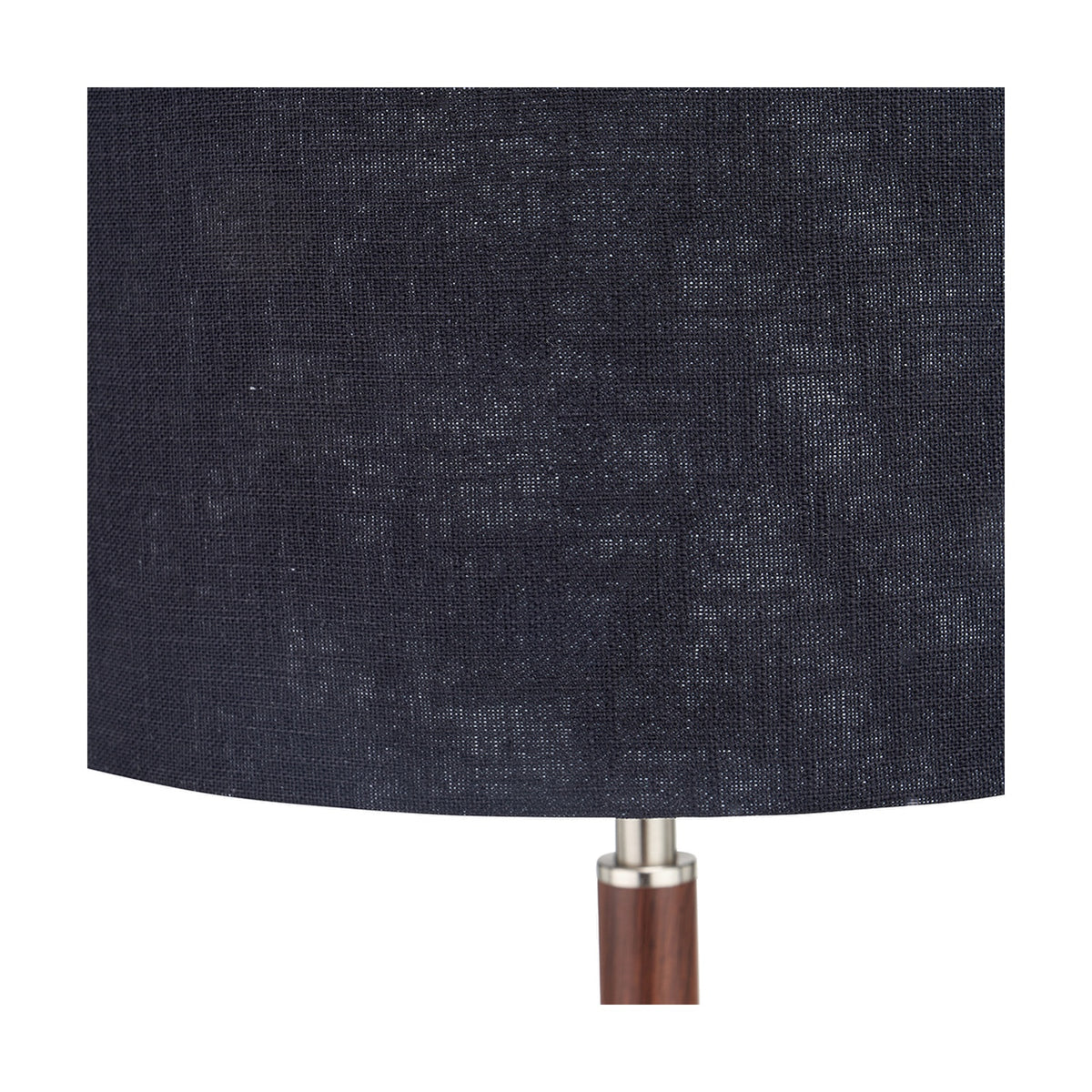 Close-up of the Gianni Table Lamp's navy linen drum shade with visible woven texture, joined to a wood-effect stem by a brushed silver collar.