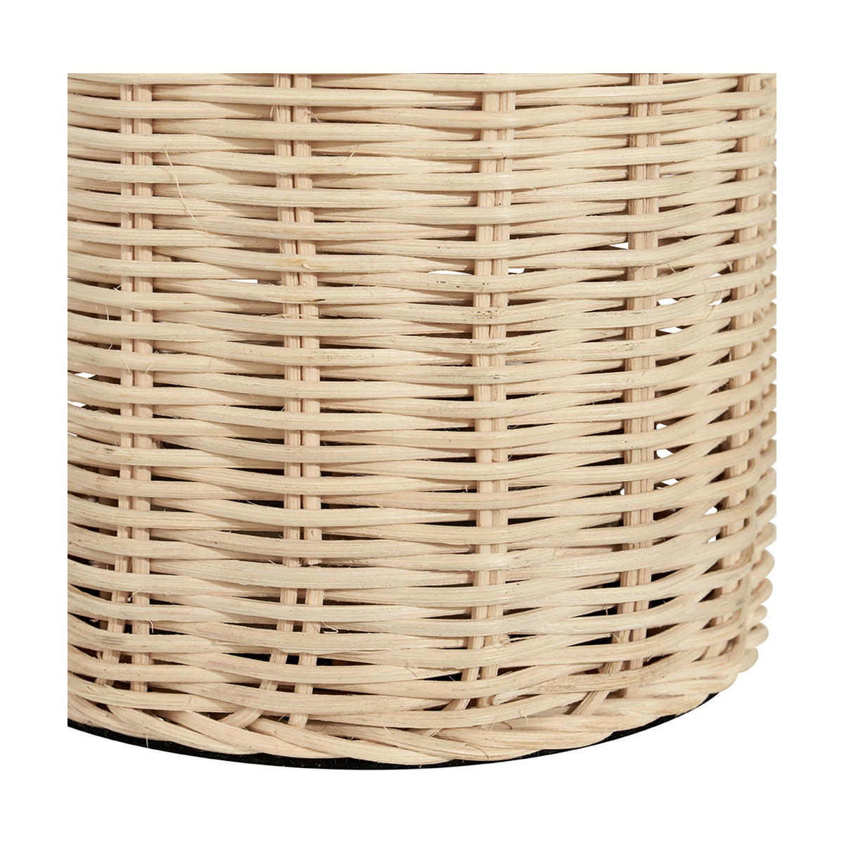 Close-up of the Anika Rattan Bottle Table Lamp's base, showing a tightly woven natural rattan surface with a curved silhouette on a plain white background.
