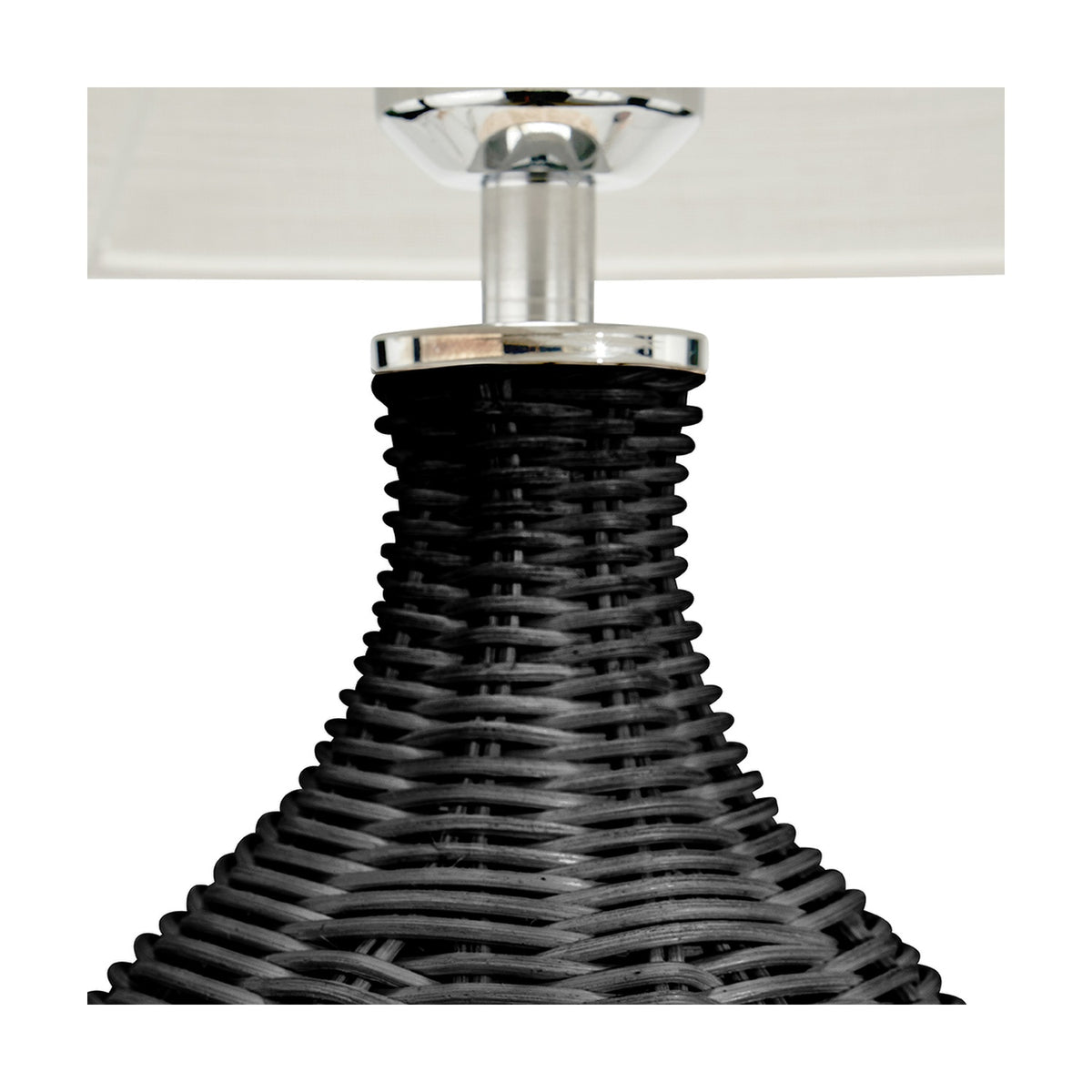 Close-up of the Anika Black Rattan Bottle Table Lamp base, showing woven black rattan tapering to a chrome fitting beneath a light linen shade.