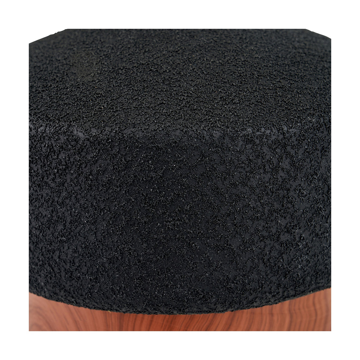 Close-up of the Elio table lamp base showing black textured ceramic finish above a wood effect ring, highlighting the rough, granular surface detail.