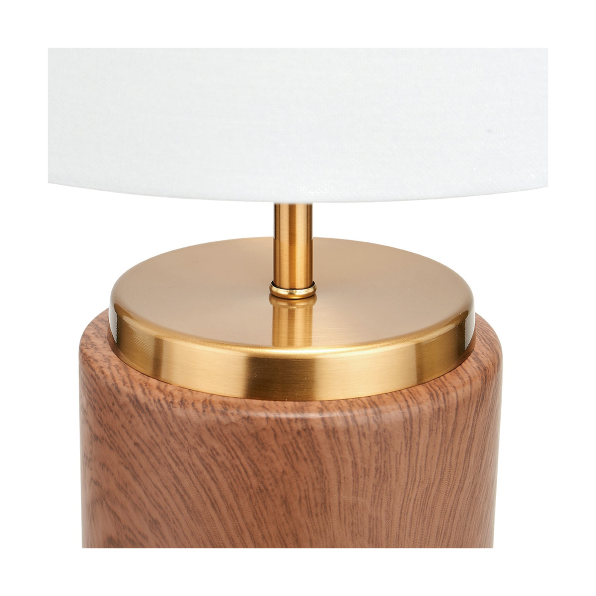 Close-up of the Carrara Wood Effect Ceramic Table Lamp base, showing a brushed brass neck and cap atop a wood-effect ceramic cylinder base, with a white fabric shade above, on a plain background.