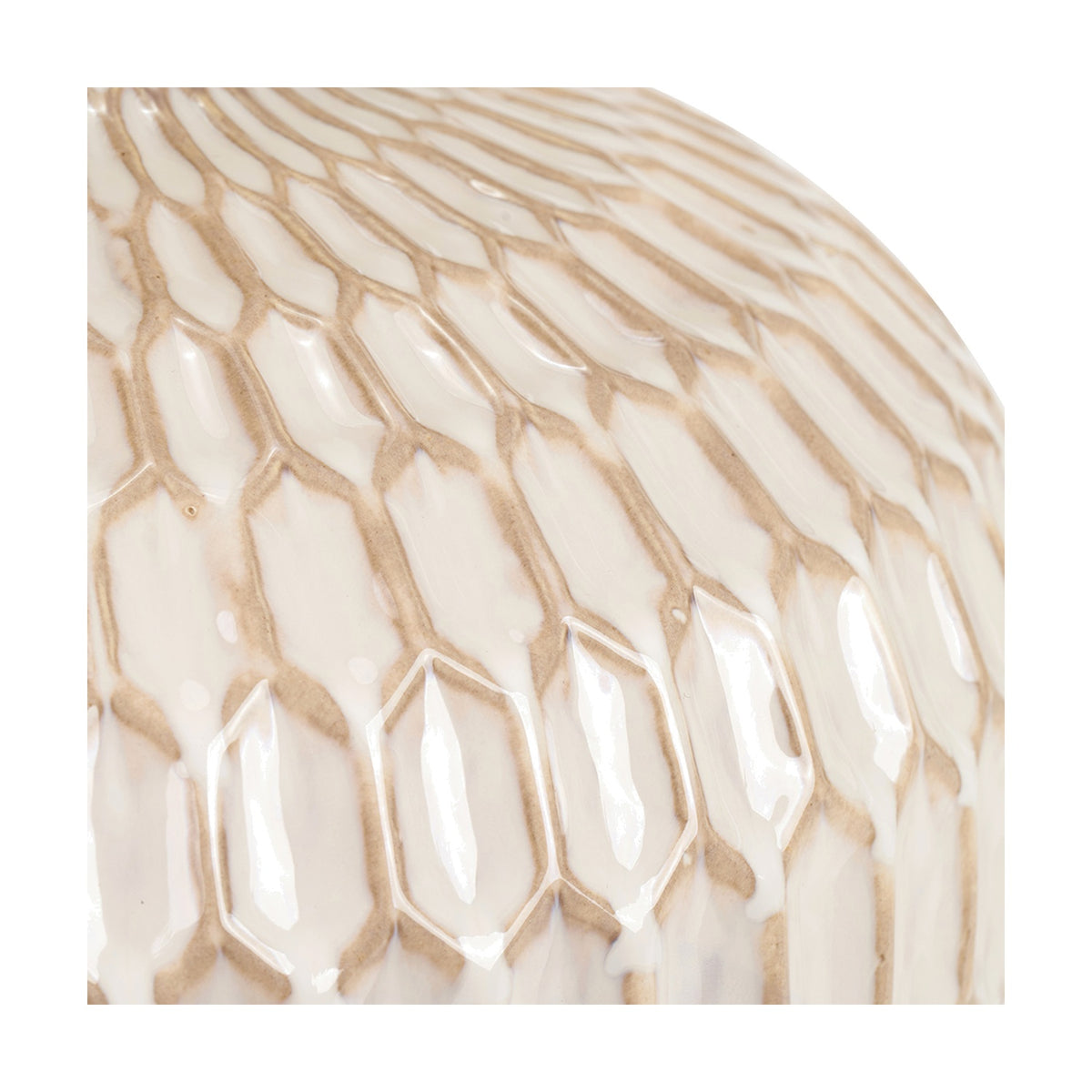 Close-up of the Cassius Warm White Textured Glazed Ceramic Table Lamp, showing raised honeycomb ridges with glossy highlights on a warm white ceramic surface.