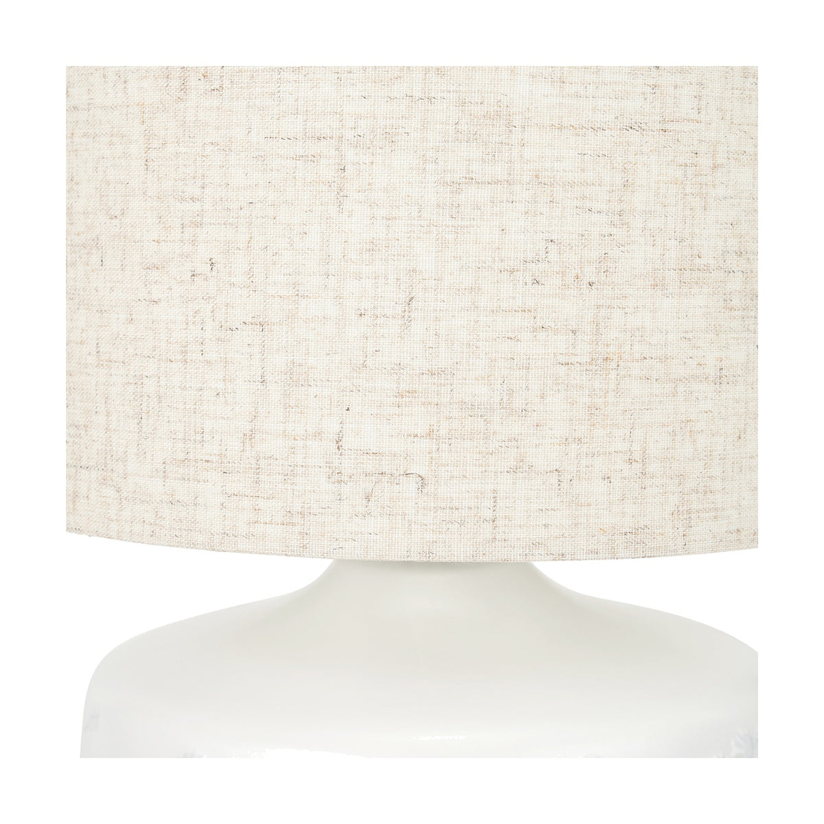 Close-up of the Flora White Small Ceramic Table Lamp, 33cm, showing a textured linen drum shade atop a glossy white ceramic base on a plain background.